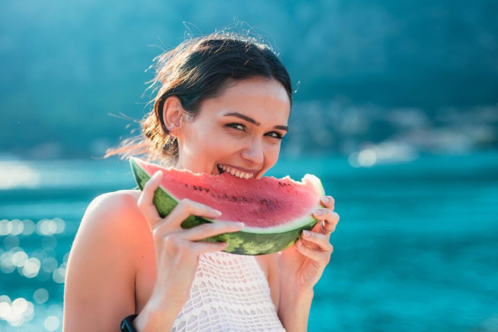 a girl eating a piece of watermelon