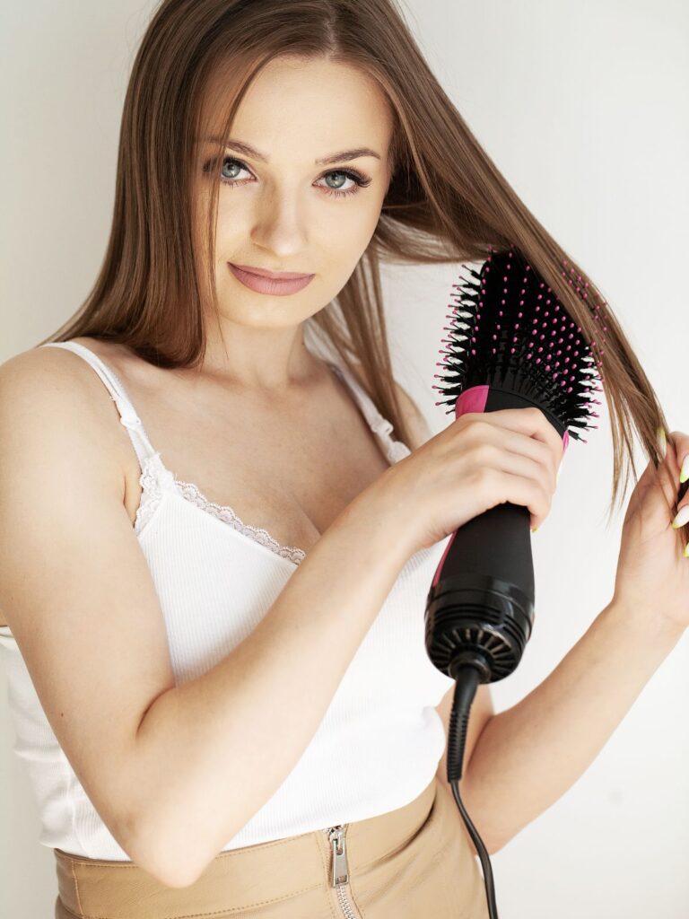 a girl holding a blow dry brush