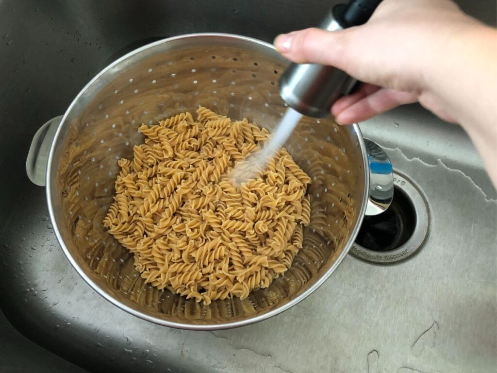 rinsing the noodles off in the sink