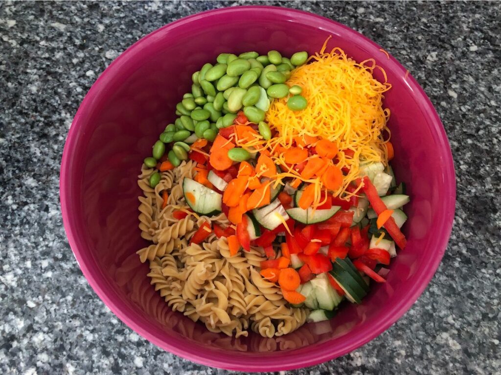 all of the ingredients for the high protein pasta salad in the bowl